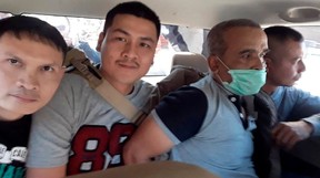 Cops take away convicted serial killer Somkid Poompuang, in mask.