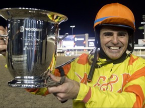Jockey Eurico Da Silva holds a trophy after riding Pumpkin Rumble to victory in the  Valedictory Stakes, the last stake of Woodbine’s 133-day thoroughbred race meet. (MICHAEL BURNS/Photo)
