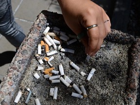 A smoker puts out a cigarette in a public ash tray in Ottawa on May 31, 2016. (THE CANADIAN PRESS/Sean Kilpatrick)