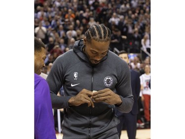 Former Raptors MVP Kawhi Leonard accepts his NBA Championship ring from former team-mate Kyle Lowry before the Raptors / Clippers game in Toronto, Ont. on Wednesday December 11, 2019.
