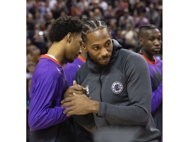 Former Raptors MVP Kawhi Leonard accepts his NBA Championship ring from former team-mate Kyle Lowry before the Raptors / Clippers game in Toronto, Ont. on Wednesday December 11, 2019.