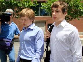 In this July 1, 2010 file photo, Alexander Vavilov, right, and his older brother brother Timothy leave a federal court after a bail hearing for their parents Donald Heathfield and Tracey Ann Foley, in Boston.