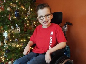 A smiling Zach Rayment, 10, next to his family's Christmas tree. (SIMON RAYMENT PHOTO)