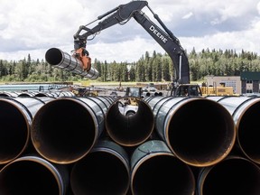 Pipe for the Trans Mountain pipeline is unloaded in Edson, Alta. on Tuesday June 18, 2019.