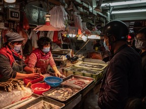 Residents wearing face masks purchase seafood at a wet market on January 28, 2020 in Macau, China.