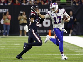 Buffalo Bills quarterback Josh Allen, right, stiff arms Justin Reid of the Houston Texans on a bootleg play during the AFC Wild Card Playoff game at NRG Stadium on Jan. 4, 2020 in Houston, Texas. (Bob Levey/Getty Images)