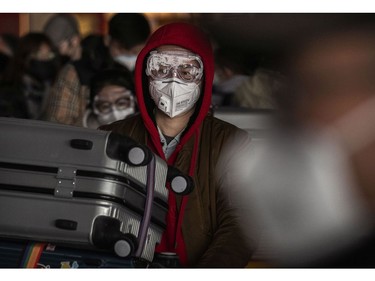 BEIJING, CHINA - JANUARY 30: A man wears a protective mask and goggles as he lines up to check in to a flight at Beijing Capital Airport on January 30, 2020 in Beijing, China. The number of cases of a deadly new coronavirus rose to over 7000 in mainland China Thursday as the country continued to lock down the city of Wuhan in an effort to contain the spread of the pneumonia-like disease which medicals experts have confirmed can be passed from human to human. In an unprecedented move, Chinese authorities put travel restrictions on the city which is the epicentre of the virus and neighbouring municipalities affecting tens of millions of people. The number of those who have died from the virus in China climbed to over 170 on Thursday, mostly in Hubei province, and cases have been reported in other countries including the United States, Canada, Australia, Japan, South Korea, and France. The World Health Organization  has warned all governments to be on alert, and its emergency committee is to meet later on Thursday to decide whether to declare a global health emergency.