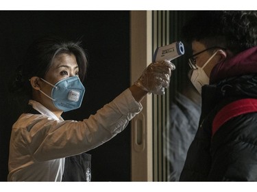 BEIJING, CHINA - JANUARY 30: A Chinese worker from Starbucks checks the temperature of a customer at Beijing Capital Airport on January 30, 2020 in Beijing, China. The number of cases of a deadly new coronavirus rose to over 7000 in mainland China Thursday as the country continued to lock down the city of Wuhan in an effort to contain the spread of the pneumonia-like disease which medicals experts have confirmed can be passed from human to human. In an unprecedented move, Chinese authorities put travel restrictions on the city which is the epicentre of the virus and neighbouring municipalities affecting tens of millions of people. The number of those who have died from the virus in China climbed to over 170 on Thursday, mostly in Hubei province, and cases have been reported in other countries including the United States, Canada, Australia, Japan, South Korea, and France. The World Health Organization  has warned all governments to be on alert, and its emergency committee is to meet later on Thursday to decide whether to declare a global health emergency.