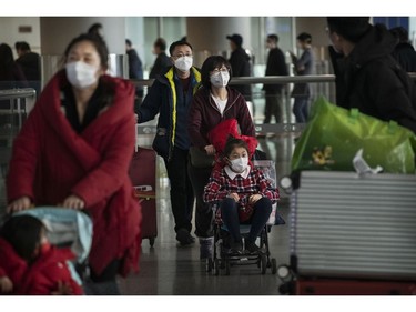 BEIJING, CHINA - JANUARY 30: Passengers wear protective masks as they arrive at Beijing Capital Airport on January 30, 2020 in Beijing, China. The number of cases of a deadly new coronavirus rose to over 7000 in mainland China Thursday as the country continued to lock down the city of Wuhan in an effort to contain the spread of the pneumonia-like disease which medicals experts have confirmed can be passed from human to human. In an unprecedented move, Chinese authorities put travel restrictions on the city which is the epicentre of the virus and neighbouring municipalities affecting tens of millions of people. The number of those who have died from the virus in China climbed to over 170 on Thursday, mostly in Hubei province, and cases have been reported in other countries including the United States, Canada, Australia, Japan, South Korea, and France. The World Health Organization  has warned all governments to be on alert, and its emergency committee is to meet later on Thursday to decide whether to declare a global health emergency.
