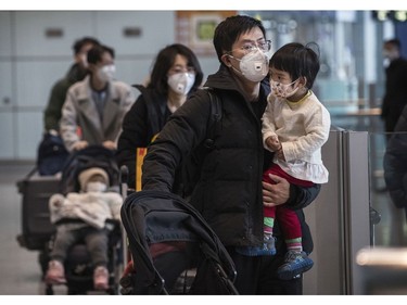 BEIJING, CHINA - JANUARY 30: Passengers wear protective masks as they walk he their luggagein the arrivals area at Beijing Capital Airport on January 30, 2020 in Beijing, China. The number of cases of a deadly new coronavirus rose to over 7000 in mainland China Thursday as the country continued to lock down the city of Wuhan in an effort to contain the spread of the pneumonia-like disease which medicals experts have confirmed can be passed from human to human. In an unprecedented move, Chinese authorities put travel restrictions on the city which is the epicentre of the virus and neighbouring municipalities affecting tens of millions of people. The number of those who have died from the virus in China climbed to over 170 on Thursday, mostly in Hubei province, and cases have been reported in other countries including the United States, Canada, Australia, Japan, South Korea, and France. The World Health Organization  has warned all governments to be on alert, and its emergency committee is to meet later on Thursday to decide whether to declare a global health emergency.