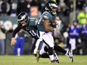 Quarterback Josh McCown of the Philadelphia Eagles is tripped by as he hands off to Boston Scott during the NFC Wild Card Playoff game against the Seattle Seahawks at Lincoln Financial Field on January 05, 2020 in Philadelphia, Pennsylvania.