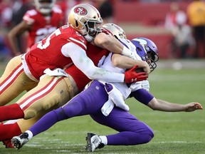 Kirk Cousins of the Minnesota Vikings is sacked by Nick Bosa and Dee Ford of the San Francisco 49ers during the second half of the NFC Divisional Round Playoff game at Levi's Stadium on January 11, 2020 in Santa Clara, California.