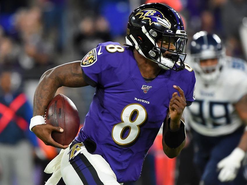 Baltimore Ravens' Lamar Jackson (8) hands off to Gus Edwards (35