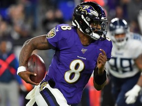Quarterback Lamar Jackson of the Baltimore Ravens carries the ball against the defense of the Tennessee Titans during the AFC Divisional Playoff game at M&T Bank Stadium on January 11, 2020 in Baltimore, Maryland.