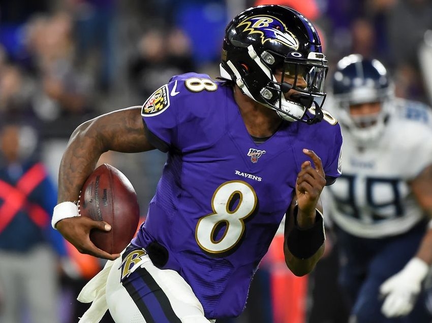 Baltimore Ravens quarterback Lamar Jackson (8) runs out of the pocket  against the Tennessee Tit …