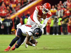 Quarterback Deshaun Watson #4 of the Houston Texans is tackled by Frank Clark #55 of the Kansas City Chiefs during the AFC Divisional playoff game. (Photo by Peter Aiken/Getty Images)