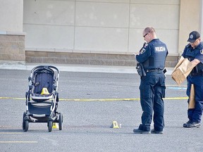 Greater Sudbury Police officers collect evidence at the site of a stabbing incident June 3 outside the Michaels store on Marcus Drive. A woman and child were injured, while the suspect, a man, also injured himself, police said.  Jim Moodie/Postmedia