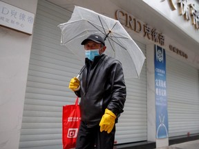 A man wears a face mask in a deserted shopping street in Jiujiang, China, on Feb. 2, 2020. (Reuters)