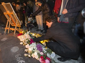 Prime Minister Justin Trudeau places a bouquet at the Centennial Flame on Parliament Hill during a vigil to remember those killed in this week's jet crash in Iran. (Postmedia Network)