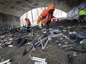 City crews clean up refuse, including used syringes, left behind by the homeless that had camped out under Bloor St. E. and TTC overpasses along Rosedale Valley Rd.  on Jan. 7, 2020. (Stan Behal, Toronto Sun)