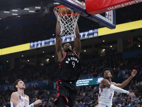 Toronto Raptors forward Serge Ibaka, centre, dunks against Oklahoma City Thunder forward Mike Muscala, left, and guard Shai Gilgeous-Alexander during the first half at Chesapeake Energy Arena, Jan. 15, 2020. (Alonzo Adams-USA TODAY Sports)