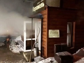 Steam comes out from a door of the Mini Hotel Caramel after a hot water pipe exploded in the night and flooded a basement hotel room with boiling water, in Perm, Russia, Jan. 20, 2020, in this screen grab taken from video. (Russian Emergencies Ministry/Handout via REUTERS)