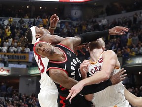 Pacers center Myles Turner (33) and forward Domantas Sabonis (11) battle for a rebound against Raptors forward Rondae Hollis-Jefferson (4) during overtime at Bankers Life Fieldhouse. Mandatory Credit: Brian Spurlock-USA Sports