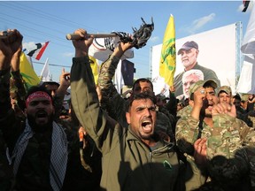 Members of the Hashed al-Shaabi paramilitary force chant anti-US slogans during a protest over the killings of Iranian commander Qassem Soleimani and Iraqi paramilitary commander Abu Mahdi Al-Muhandis, on January 6, 2020 in Karrada in central Baghdad.