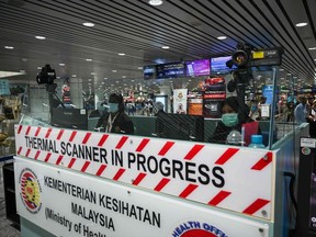 Malaysian health officer screens arriving passengers with thermal scanners at Kuala Lumpur International Airport in Sepang on January 21, 2020 as authorities increased measure against coronavirus.