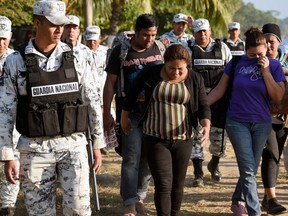 A Central American migrant family is escorted by members of the Mexican National Guard and officers of the Migration Institute after being detained crossing the Suchiate River, the natural border with Tecum Uman in Guatemala, in Ciudad Hidalgo, Chiapas State, Mexico on January 22, 2020.