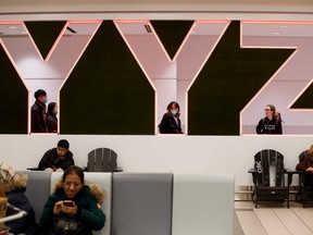 Travellers are seen wearing masks at the international arrivals area at the Toronto Pearson Airport in Toronto, Canada on Jan. 26, 2020.