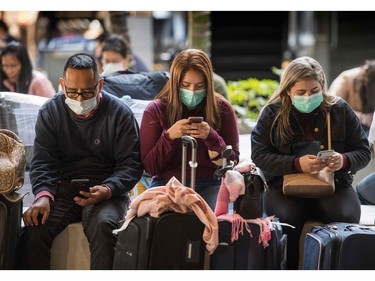 Passengers wear face masks to protect against the spread of the Coronavirus as they arrive on a flight from Asia at Los Angeles International Airport, California, on January 29, 2020. - A new virus that has killed more than one hundred people, infected thousands and has already reached the US could mutate and spread, China warned, as authorities urged people to steer clear of Wuhan, the city at the heart of the outbreak. (Photo by Mark RALSTON / AFP)