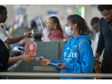 A passenger wears a mask as she waits at passport control in Bole International Airport in Addis Ababa, on January 30, 2020, following an outbreak of coronavirus in China. - As of January 30, some 7,700 cases have been confirmed in China, its country of origin, with at least 170 fatalities. The virus has spread from the city of Wuhan across China to more than 15 countries, with about 60 cases in Asia, Europe, North America and, most recently, the Middle East. (Photo by Michael Tewelde / AFP)