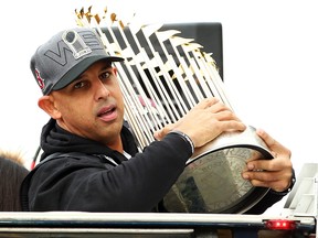 Boston Red Sox Manager Alex Cora holds the World Series trophy during the team’s victory parade on Oct. 31, 2018 in Boston.