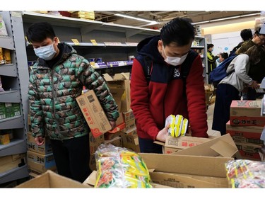 Customers wear masks as they shop for instant noodles at a supermarket following the outbreak of a new coronavirus, in Hong Kong, China January 30, 2020. REUTERS/Tyrone Siu ORG XMIT: GGGTS07