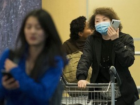 A passenger wears a mask at the international arrivals area at the Vancouver International Airport in Richmond, B.C., Thursday, January 23, 2020.