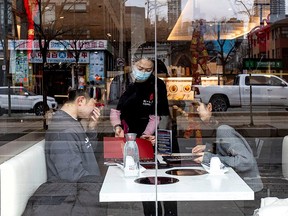 A server attends to customers at a restaurant in the Chinatown district of downtown Toronto, after three patients with novel coronavirus were reported in Canada Jan. 28, 2020.