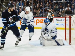 Maple Leafs goalie Frederik Andersen (right) makes a save as defenceman Justin Holl (3) blocks out Jets forward Jack Roslovic (28) during the second period at Bell MTS Place in Winnipeg, Thursday, Jan. 2, 2020.