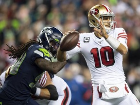 San Francisco 49ers quarterback Jimmy Garoppolo (10) passes the ball with Seattle Seahawks defensive end Jadeveon Clowney (90) chasing at CenturyLink Field. (Steven Bisig-USA TODAY Sports)