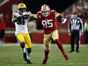 Tight end George Kittle (right) of the 49ers carries the ball after making a catch as strong safety Adrian Amos (left) of the Packers chases during NFL action at Levi's Stadium in Santa Clara, Calif., Nov. 24, 2019.