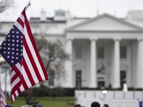 An anti-war protestor holds an upside-down American Flag during a demonstration against war in Iraq and Iran outside the White House on January 4, 2020 in Washington, DC.