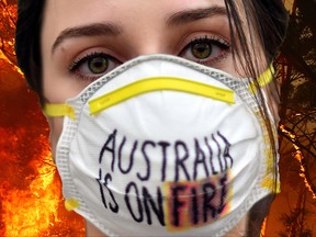 SYDNEY, AUSTRALIA - DECEMBER 19: Fire and Rescue personal run to move their truck as a bushfire burns next to a major road and homes on the outskirts of the town of Bilpin on December 19, 2019 in Sydney, Australia. NSW Premier Gladys Berejiklian has declared a state of emergency for the next seven days with ongoing dangerous fire conditions and almost 100 bushfires burning across the state. It's the second state of emergency declared in NSW since the start of the bushfire season.  (Photo by David Gray/Getty Images)