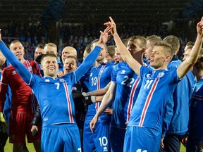 Iceland's players including Iceland's forward Johann Berg Gudmundsson (L) and Iceland's forward Alfred Finnbogason celebrate after the FIFA World Cup 2018 qualification football match between Iceland and Kosovo in Reykjavik, Iceland on October 9, 2017. Iceland qualified for the FIFA World Cup 2018 as smallest country ever after beating Kosovo 2-0 at home in Reykjavik.