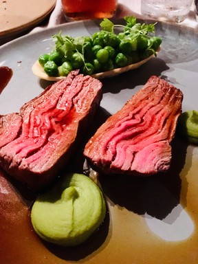 A juicy and succulent cut of veal striploin is served with peas, bacon and sweetbreads at Chez Muffy in Quebec City.
