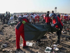 Red Crescent workers check plastic bags at the site where the Ukraine International Airlines plane crashed after take-off from Iran's Imam Khomeini airport, on the outskirts of Tehran, Iran Jan. 8, 2020.