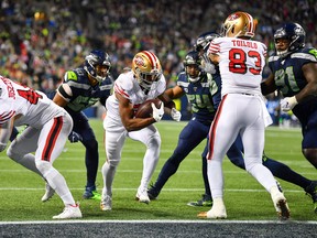 San Francisco's Raheem Mostert (centre) runs for a two-yard touchdown against the Seattle Seahawks on Dec. 29. Mostert lef the 49ers in rushing with 772 yards and a 5.6 yard per average carry, tops in the NFL among backs with at least 100 carries. (Alika Jenner/Getty Images)