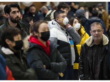 CP-Web.  People wear masks as they wait for the arrivals at the International terminal at Toronto Pearson International Airport in Toronto on Saturday, January 25, 2020. Leaders of Toronto's Chinese community said Wednesday the racist attitudes that led to widespread discrimination against Chinese Canadians during the SARS epidemic are threatening to resurface during the current outbreak of a new coronavirus.THE CANADIAN PRESS/Nathan Denette ORG XMIT: CPT132