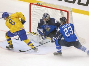 From left, Rasmus Sandin of Sweden, goalkeeper Justus Annunen and Ville Petman of Finland in action at the World Junior Hockey Championships in Trinec, Czech Republic, Dec. 26, 2019.