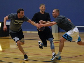 Ryan Coleman (middle,Team Grande Prairie) is blocked by Steve Sir (left, Team Edmonton) and Jordan Baker (right, Team Edmonton) during a practice at Saville Community Sports Centre in Edmonton on Sept. 27, 2019.