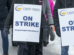 Teachers walk along Longfields Dr in Barrhaven as the OSSTF in Ottawa stage a one day strike. (Wayne Cuddington/Postmedia Network)
